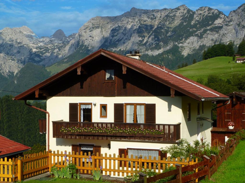 a house with a wooden fence in front of a mountain at Haus Talblick in Ramsau