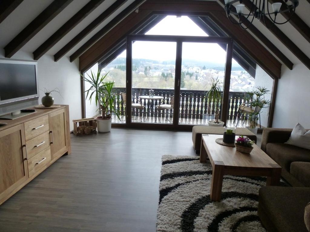 uma sala de estar com uma grande janela e um sofá em Eifel Panoramablick em Kelberg