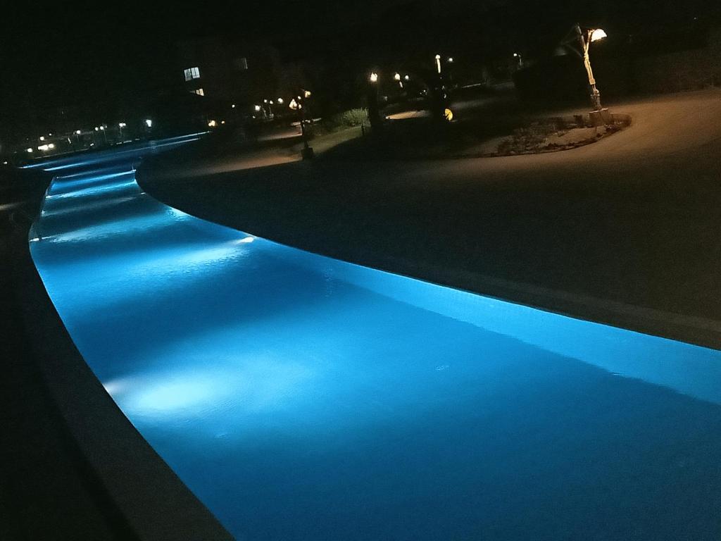 a pool with blue lights in the water at night at Marina Wadi Degla villa duplex 4 Rooms Ain Sokhna in Ain Sokhna