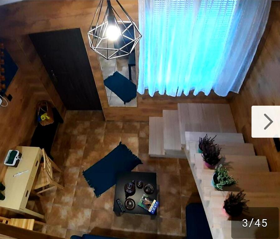 vista sul soffitto di un soggiorno con tavolo di Pokoj z antresolą a Chełmno