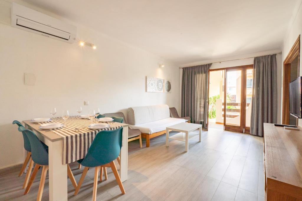een eetkamer en een woonkamer met een tafel en stoelen bij Apartamentos Estanques in Colonia Sant Jordi
