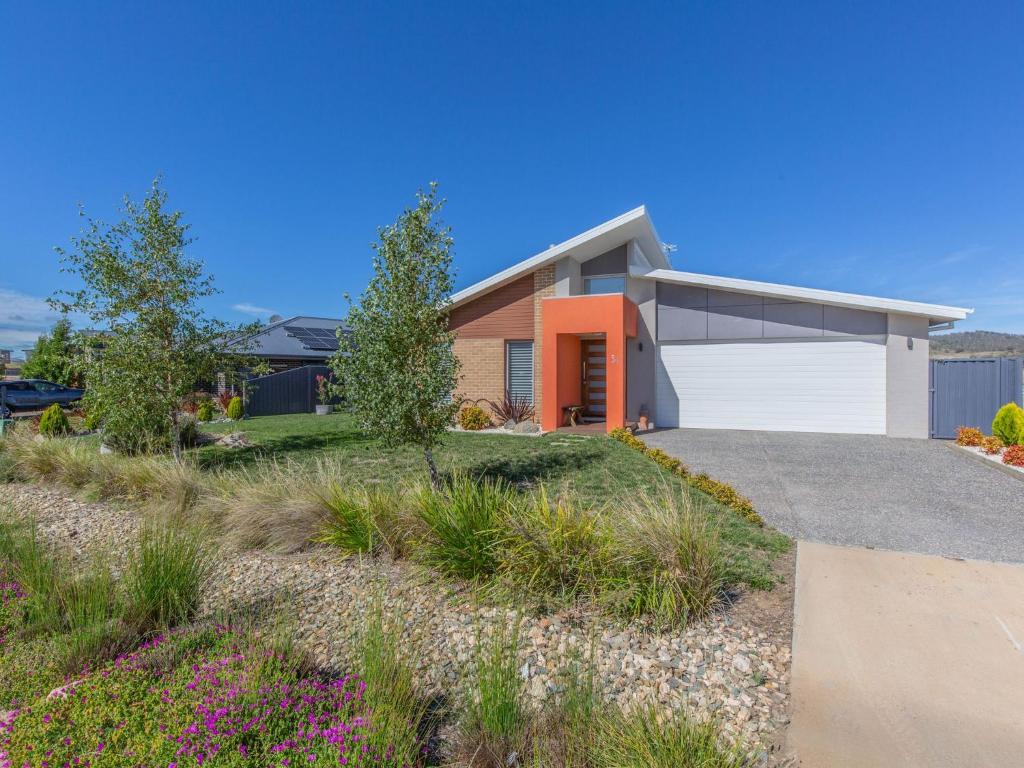 una casa con una puerta naranja y un camino de entrada en Jindalee 3 34 Twynam St, en Jindabyne