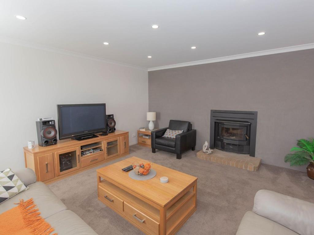 a living room with a tv and a fireplace at Jindalee 3 34 Twynam St in Jindabyne