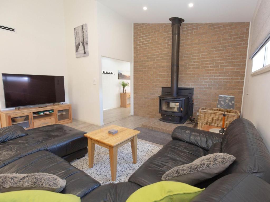 a living room with a couch and a fireplace at Jindalee 3 34 Twynam St in Jindabyne
