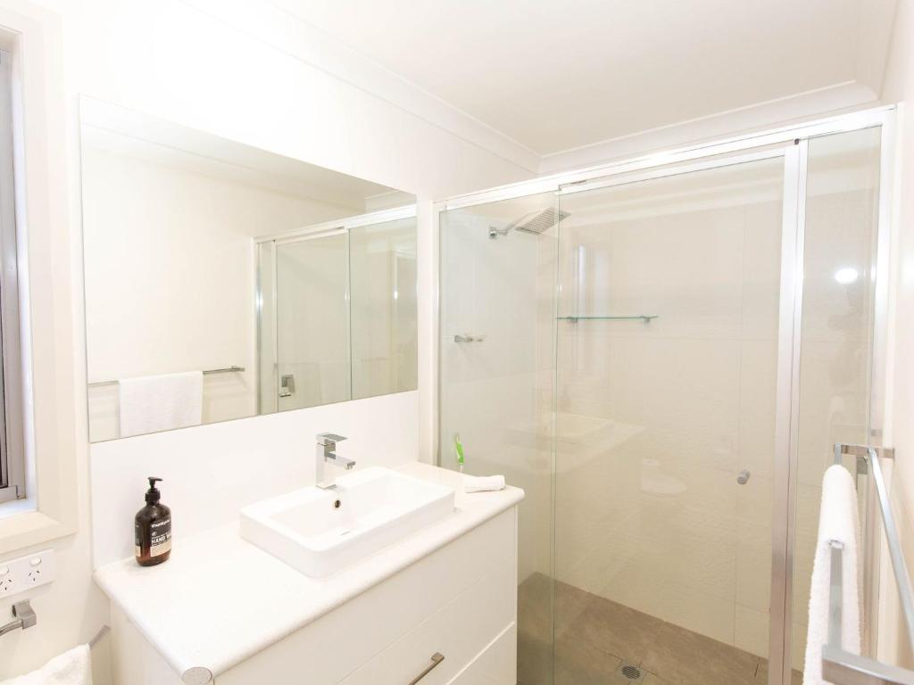 a white bathroom with a sink and a shower at Jindalee 3 34 Twynam St in Jindabyne