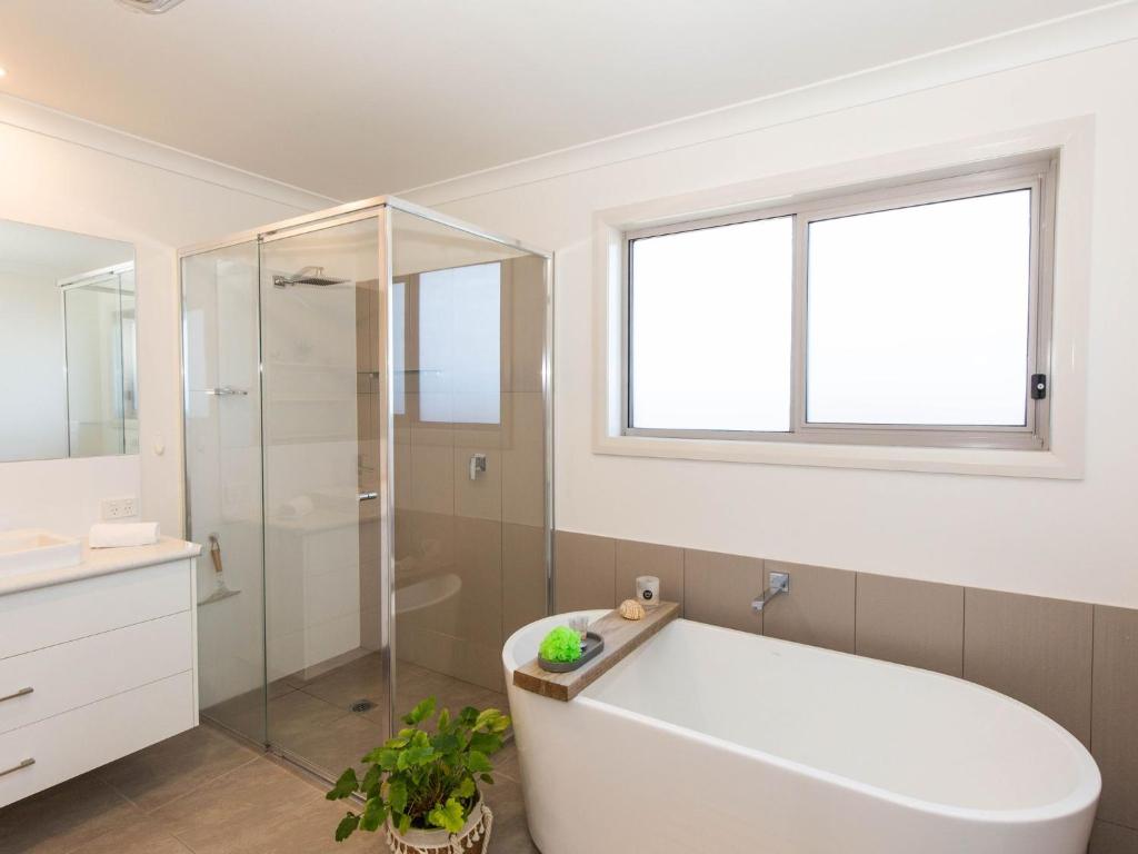 a bathroom with a tub and a glass shower at Jindalee 3 34 Twynam St in Jindabyne