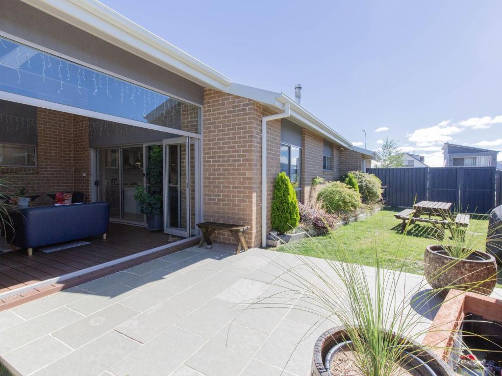 a brick house with a patio and a yard at Jindalee 3 34 Twynam St in Jindabyne