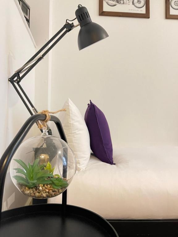 a lamp with a fish bowl on a table next to a couch at Central Located Two Bedroom Suite in Bristol