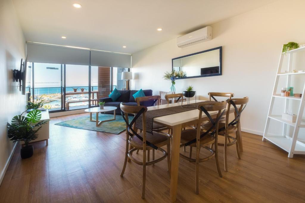 a dining room and living room with a table and chairs at Waterfront Apartments Marinaquays -Apt 221 and Apt 234 in Werribee South