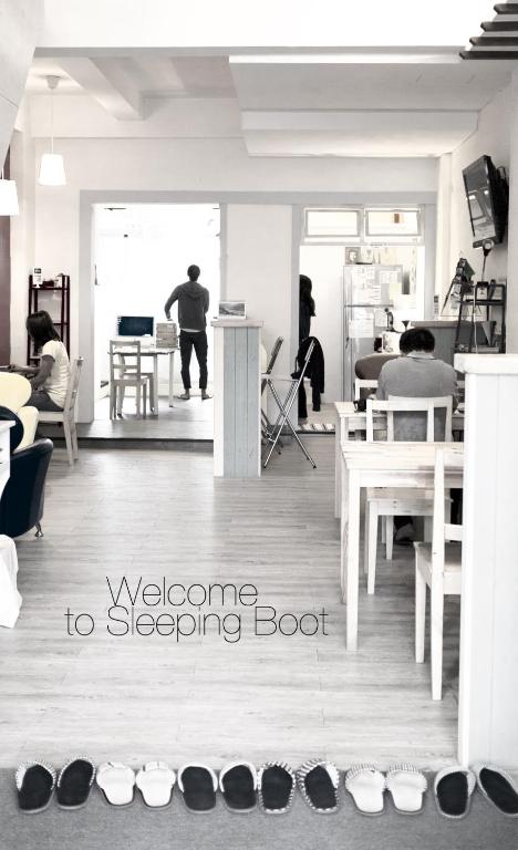 a group of people in a room with shoes on the floor at Sleeping Boot Hostel in Hualien City