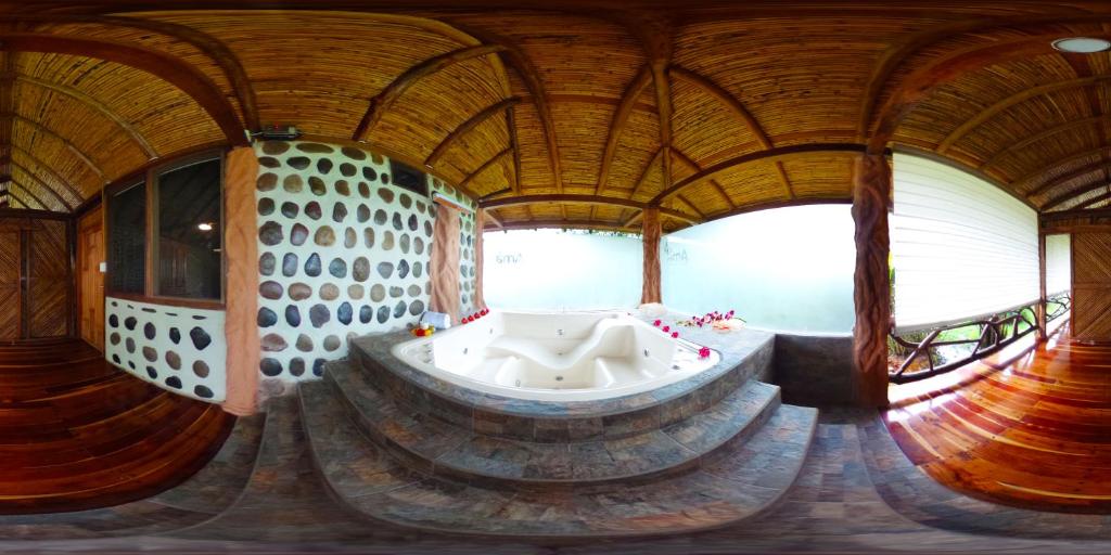 a large bathroom with a tub in the middle of a room at Ama Ecolodge in Puerto Misahuallí