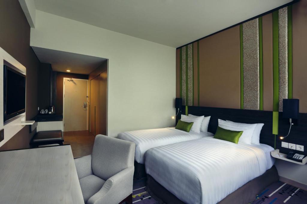 Postel nebo postele na pokoji v ubytování Mercure Serpong Alam Sutera