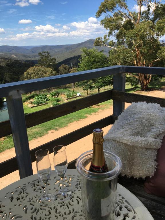 a table with two wine glasses and a bottle at Springmead Rustic Cabin in Rydal