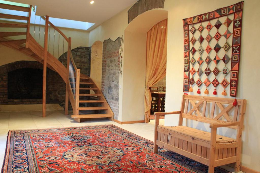 ein Wohnzimmer mit einer Treppe und einem Teppich in der Unterkunft Villa Kursa in Sighnaghi
