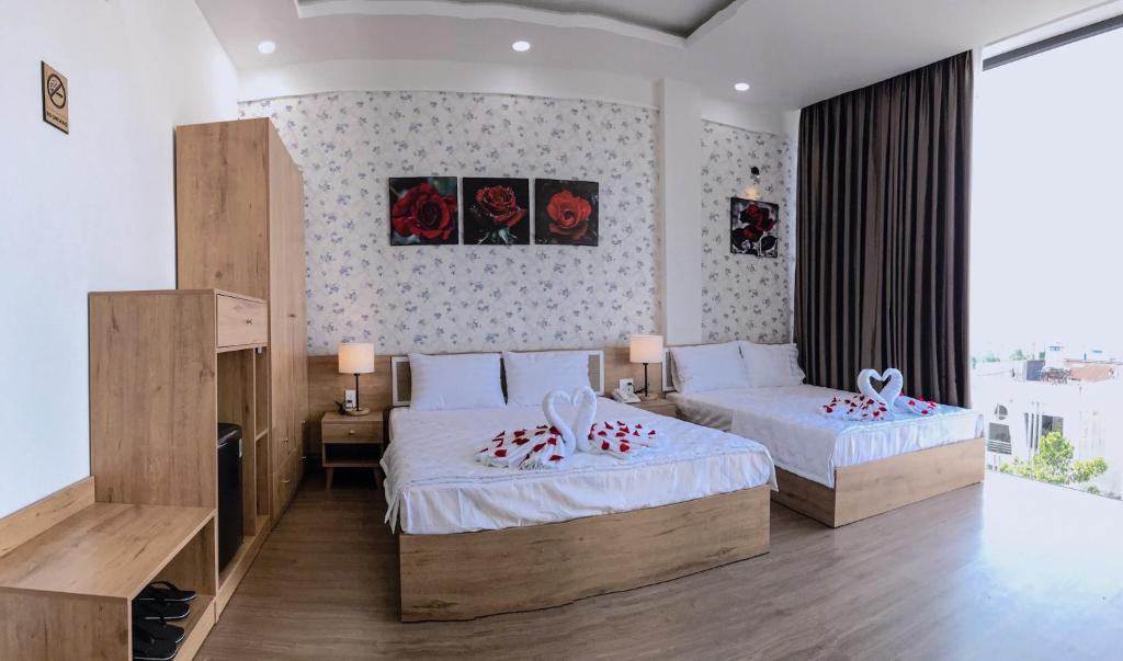 1 dormitorio con 2 camas y ventana grande en Khách sạn Sky, en Bao Loc