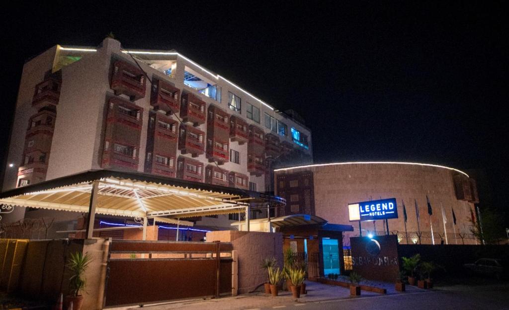 un edificio con un cartel delante de él por la noche en Legend Hotel Islamabad, en Islamabad