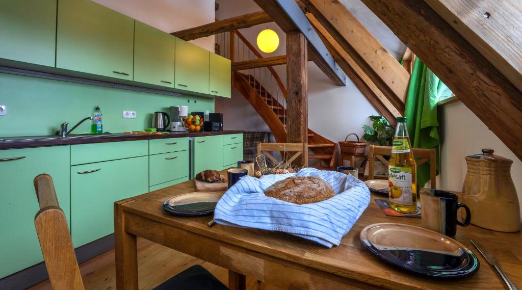 una cucina con tavolo e pagnotta di pane di Romantische Ferien auf dem nachhaltig ökologisch sanierten Bauernhof a Habrachćicy