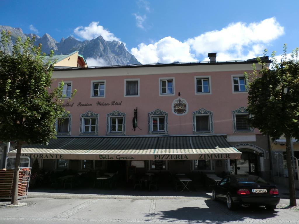 a building with a car parked in front of it at Weisses Rössl Werfen in Werfen