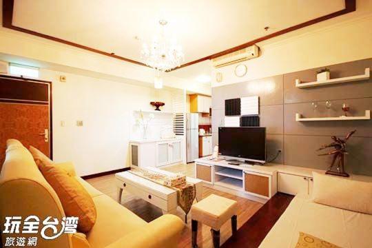 a living room with a couch and a tv at MB Hotel in Kaohsiung