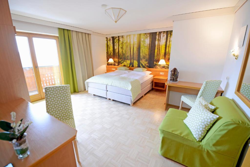 a hotel room with a bed and a table and chairs at Gasthof Thomann in Velden am Wörthersee