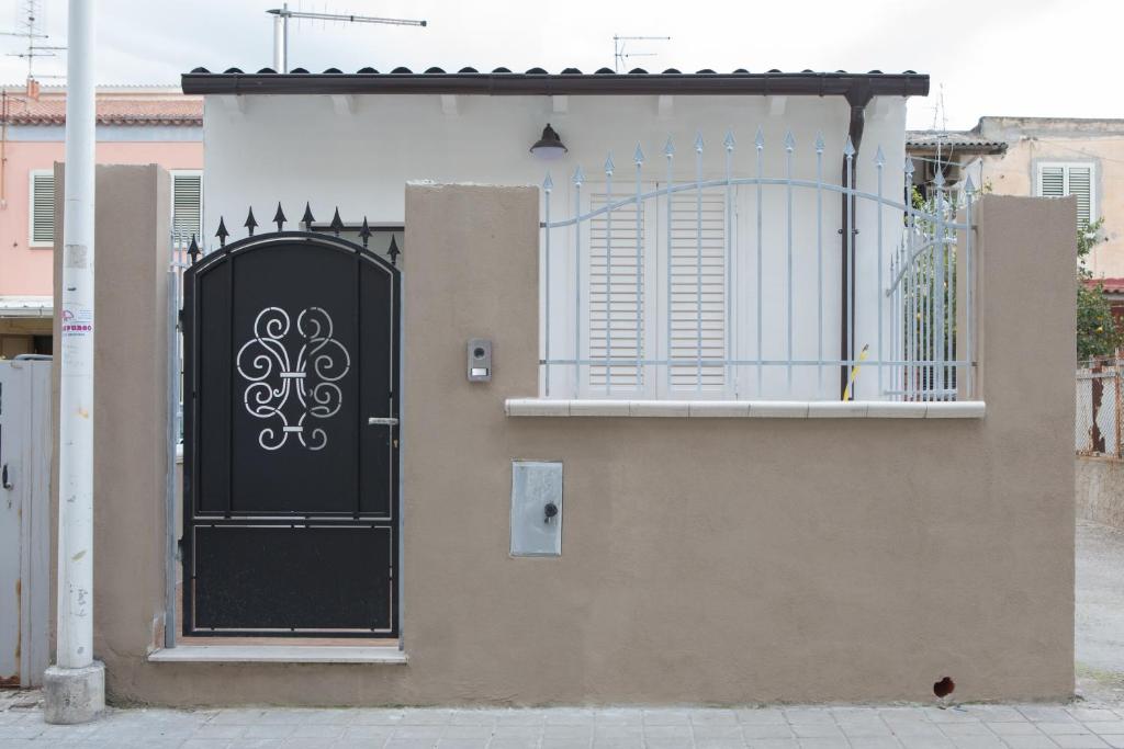 een zwarte deur aan de zijkant van een huis bij La Casetta in Quartu SantʼElena