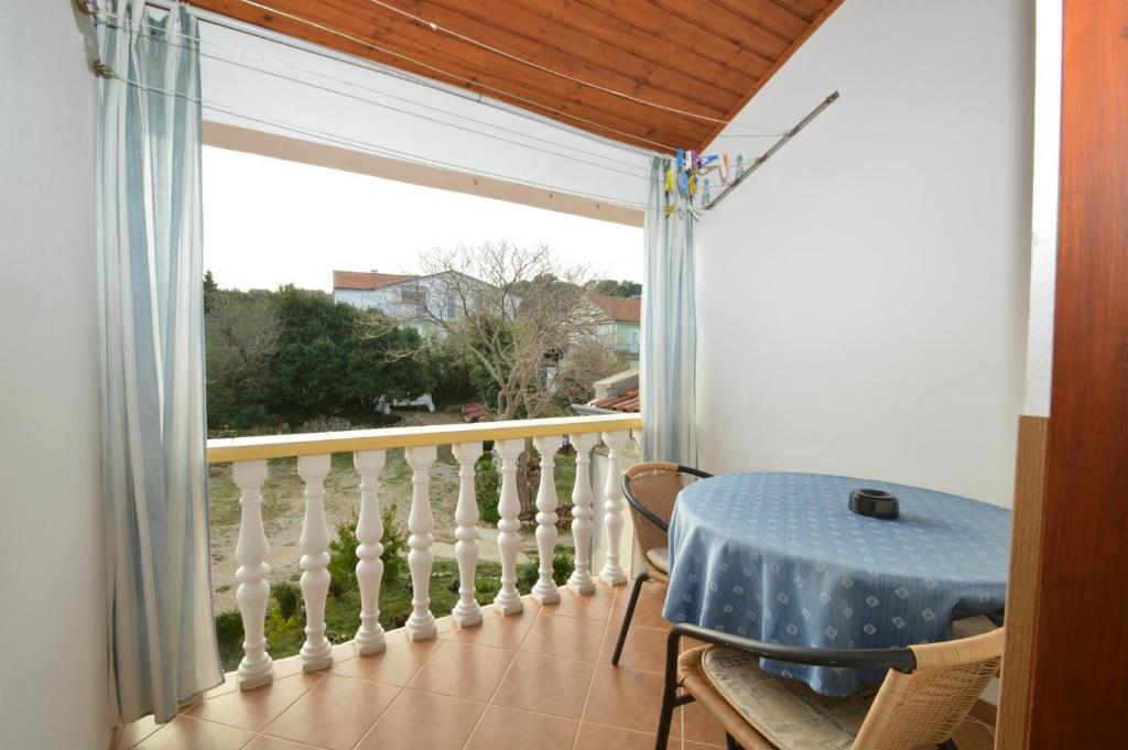 balkon ze stołem i dużym oknem w obiekcie Apartment Jasmina w miejscowości Mali Lošinj