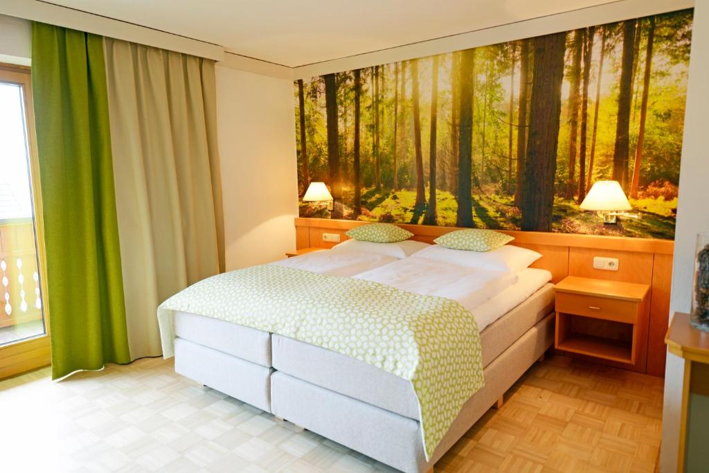 a bedroom with a bed with a painting on the wall at Gasthof Thomann in Velden am Wörthersee