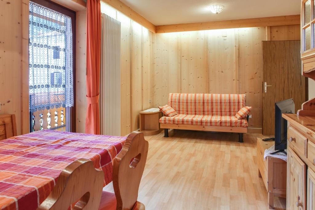 ein Schlafzimmer mit einem Bett, einem Stuhl und einem TV in der Unterkunft Casa March 1 in Moena