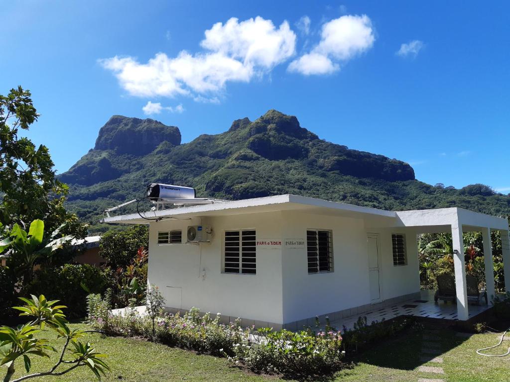 a white house with mountains in the background at Fare o'Eden in Bora Bora