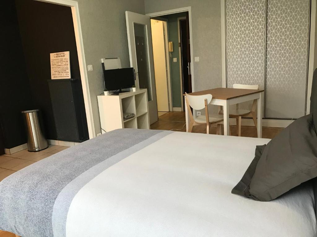 une chambre avec un lit, une table et une télévision dans l'établissement Cosylocation La Varende 38, à Rennes