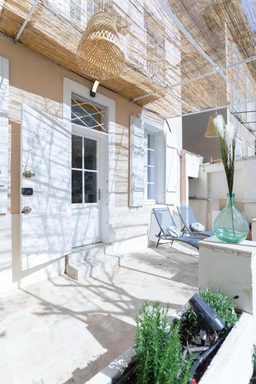 une terrasse avec une chaise et un vase de fleurs dans l'établissement La Maison de Famille 3 chambres 8 pers Terrasse Parking Clim, à Marseille