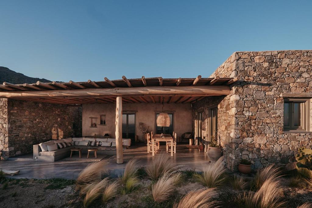 uma casa de pedra com uma pérgula de madeira em Pénde Natura Residences em Rámos