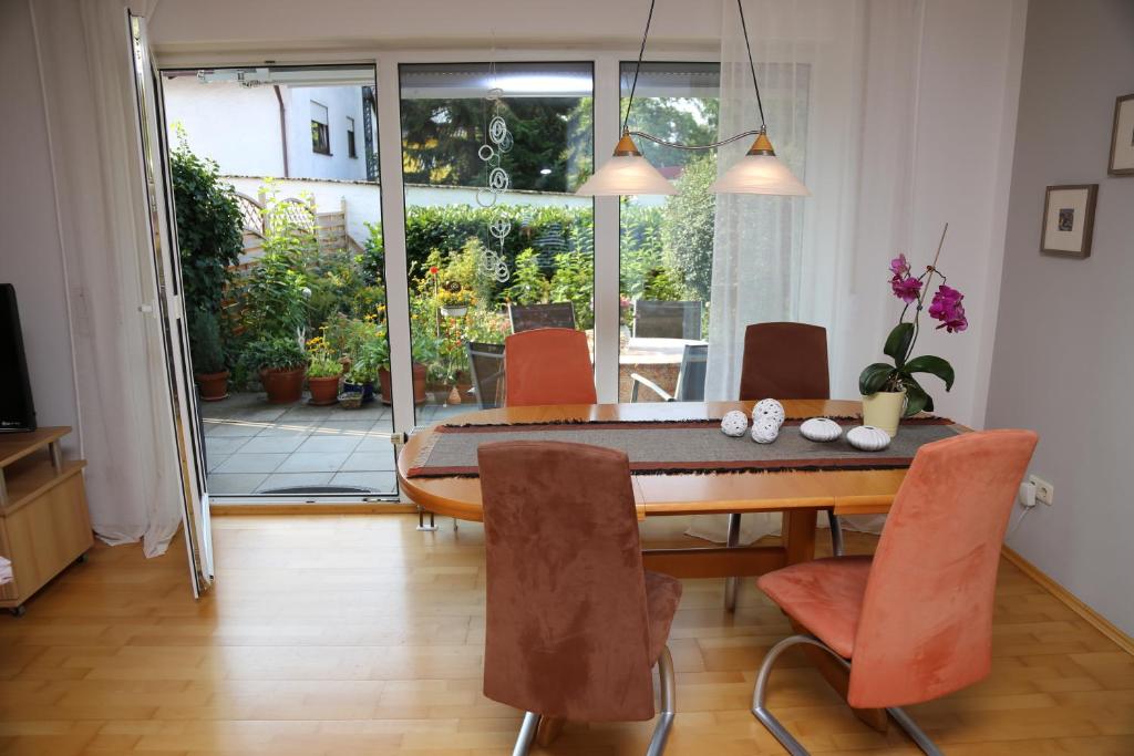 福希海姆的住宿－FeWo "Regnitztraum" in Forchheim - 3-Zimmer-Apartment - 2 Schlafzimmer，配有木桌和橙色椅子的用餐室