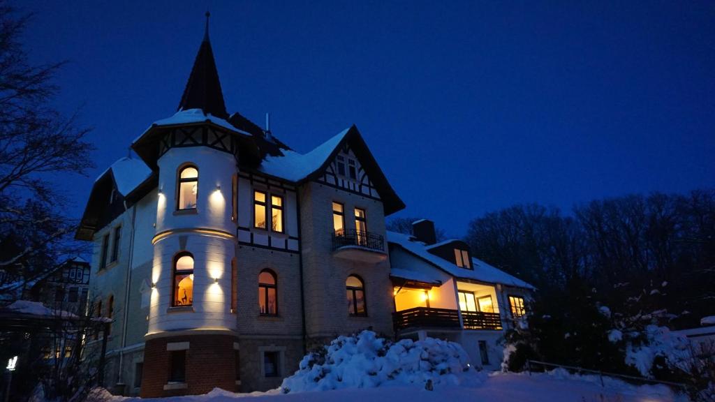 a house with lights on in the snow at night at Ferienhaus "Vier Jahreszeiten" in Bad Sachsa