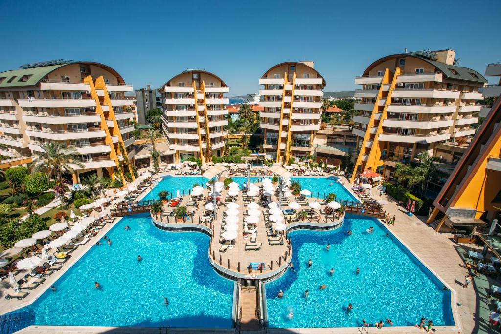 een luchtzicht op een zwembad van het resort met stoelen en parasols bij Alaiye Resort & Spa Hotel - Ultra All Inclusive in Avsallar