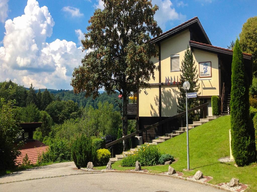 ein Haus auf einem Hügel mit einer Straße davor in der Unterkunft Ferienwohnung Vogel in Siegsdorf