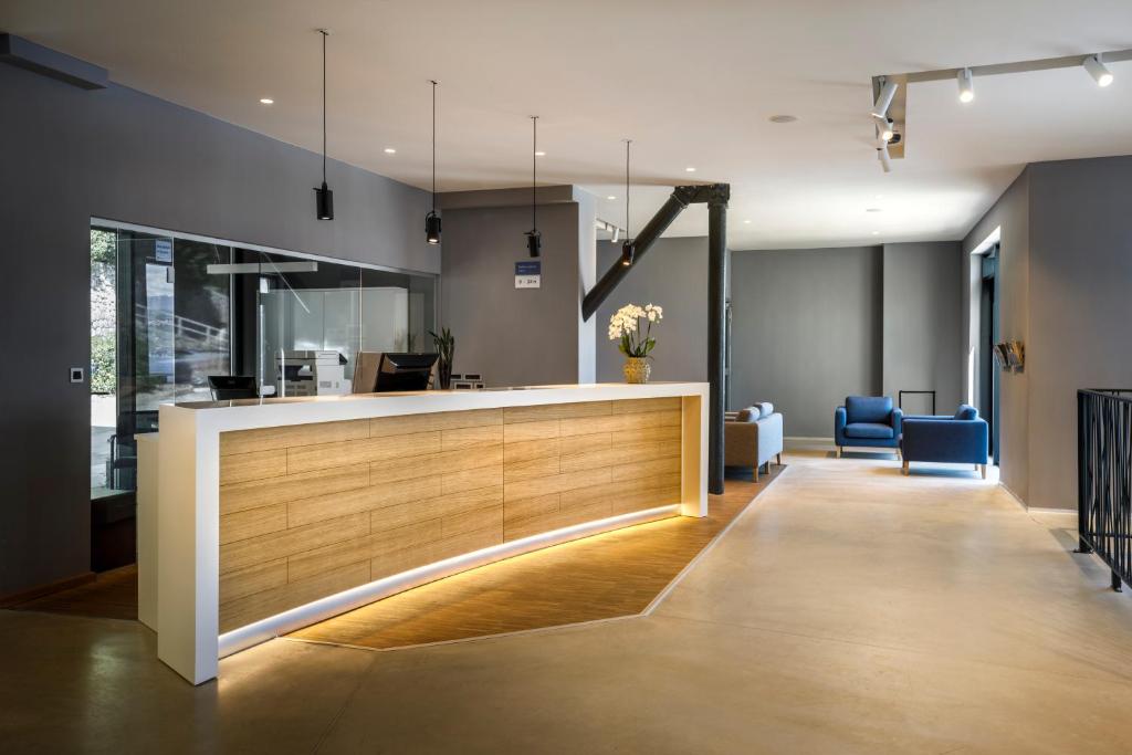 an office lobby with a reception counter and blue chairs at Hotel Istra - Liburnia in Opatija