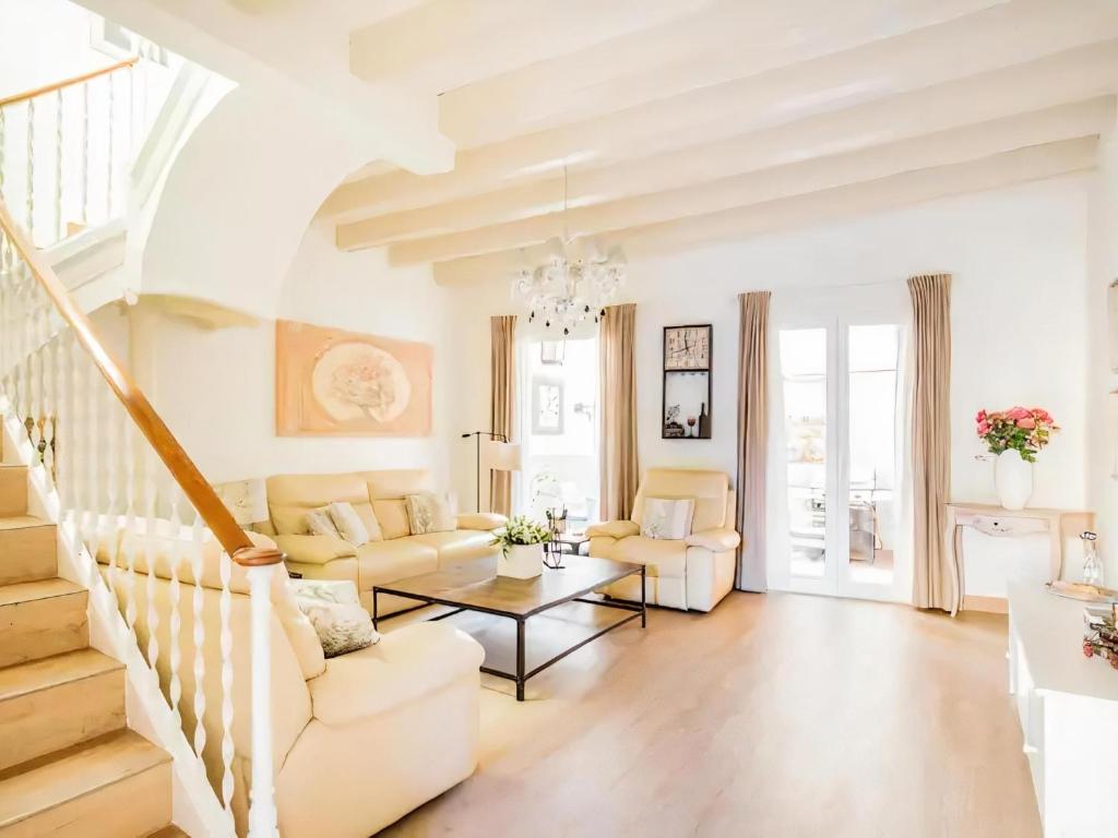 una sala de estar con muebles blancos y una escalera. en Sitges Spaces Beach House-4 bedrooms, 3 Bathrooms, Large Terrace, Jacuzzi, Center-Beach, en Sitges