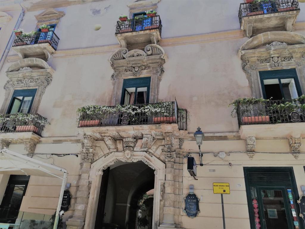 un edificio con balcones y macetas. en Ai Lumi en Trapani