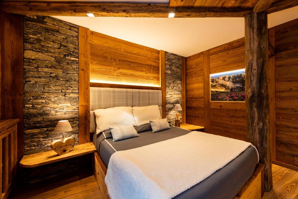 1 dormitorio con 1 cama en una habitación con paredes de madera en Hotel Valle Pesio Ristorante en Chiusa di Pesio