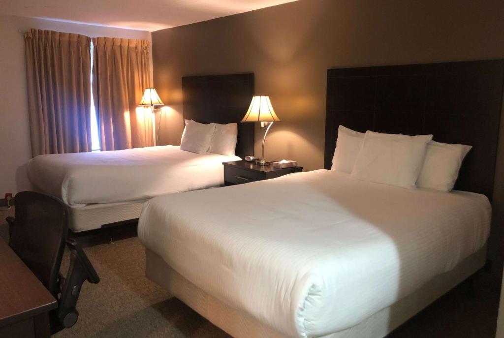 Habitación de hotel con 2 camas y 2 lámparas en Ramada by Wyndham Lindsay, en Lindsay