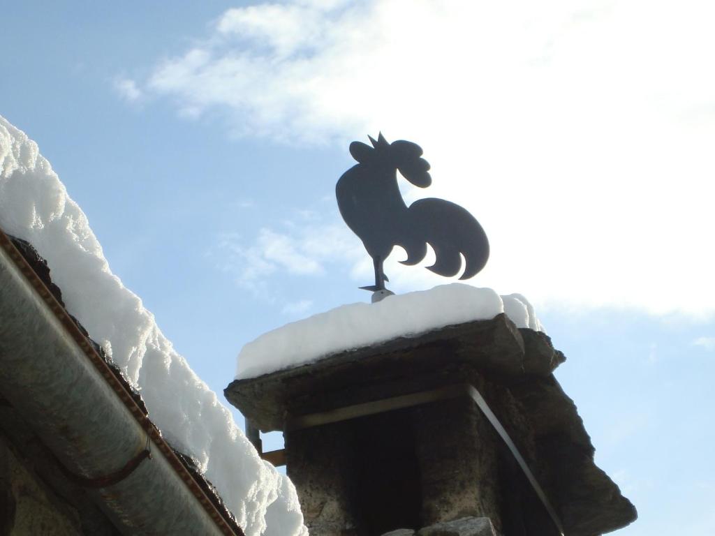 posąg kozła na dachu budynku ze śniegiem w obiekcie B&B La Quana w mieście Domodossola