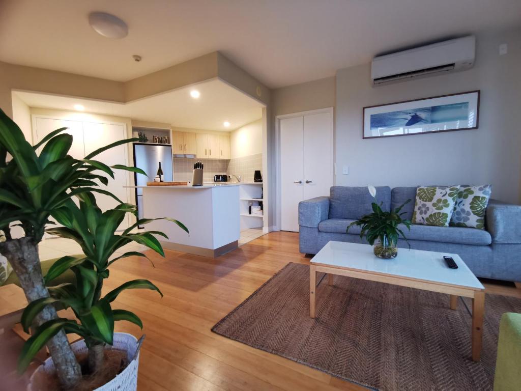 un soggiorno con divano blu e tavolo di Salt - 2brm apartment with Spa bath and Ocean Views a Kingscliff