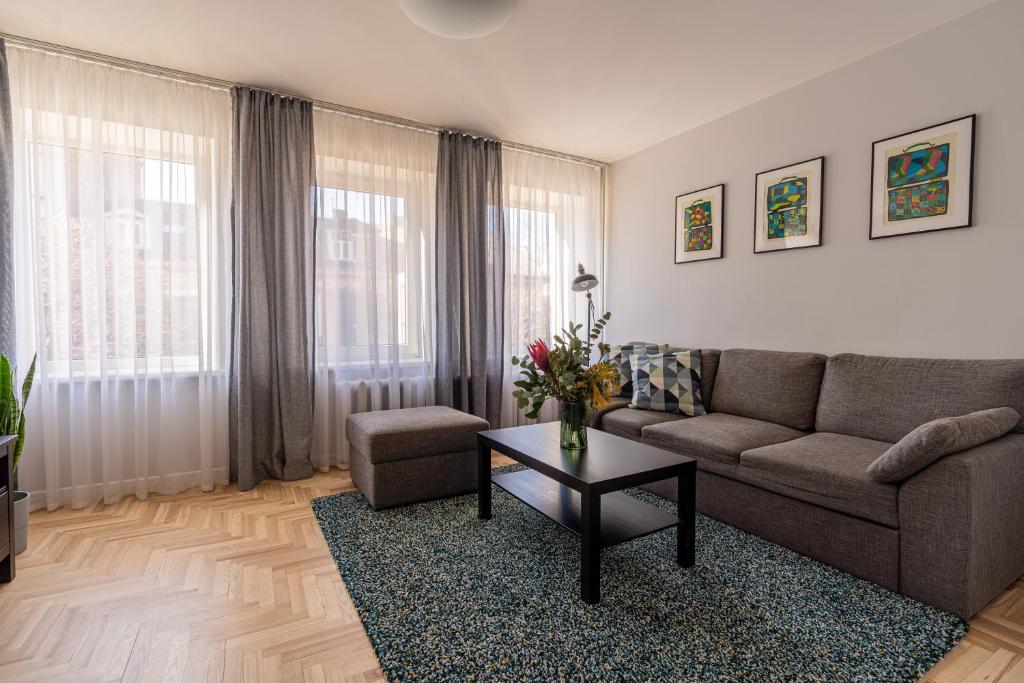 een woonkamer met een bank en een tafel bij Lovely apartment in the city center in Kaunas