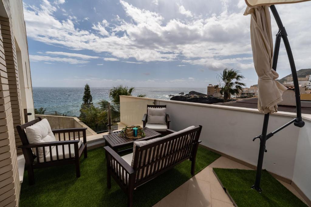een balkon met een tafel en stoelen en de oceaan bij Apartamento LUXURY en Cala Flores in Cabo de Palos