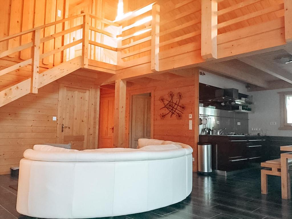 een woonkamer met een trap en een witte bank bij Chez Siouab in Saint-Hostien