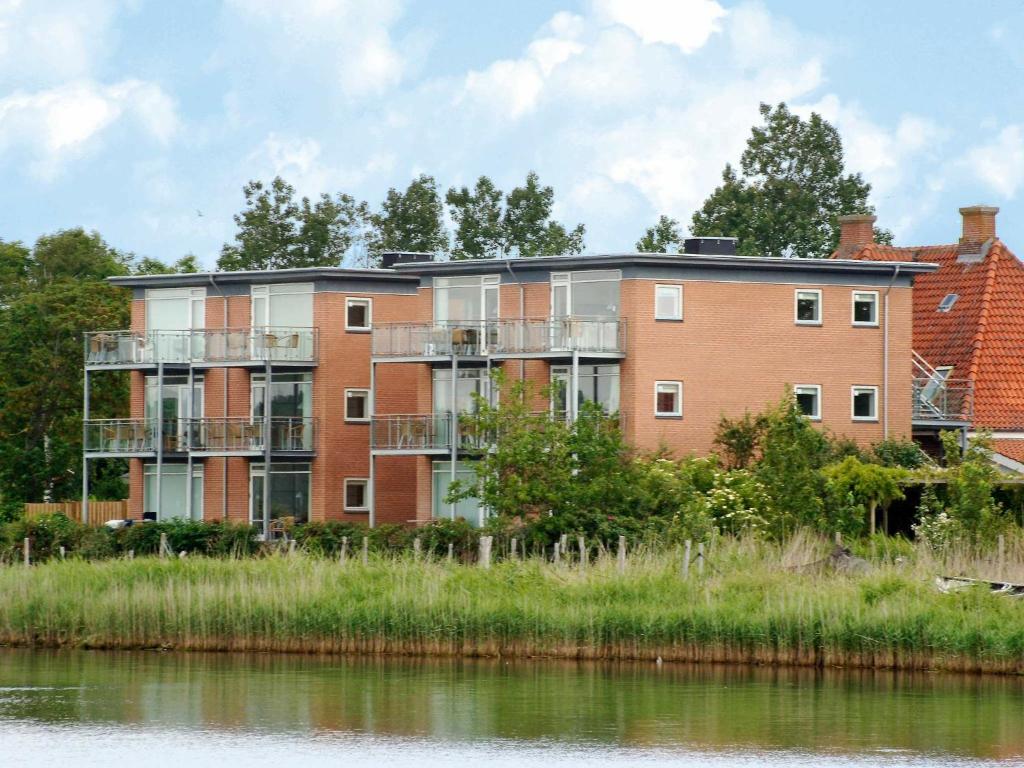 an apartment building next to a body of water at Holiday Home Banedæmningen II in Hejls