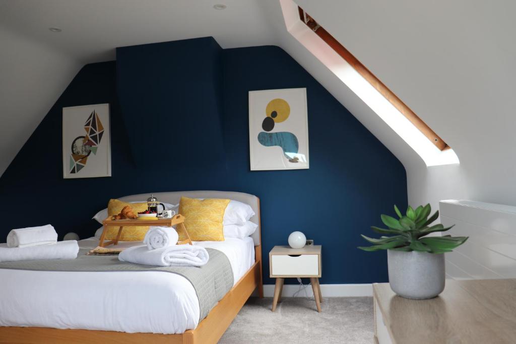 sypialnia z niebieską ścianą i łóżkiem w obiekcie Hinksey Heights w Oksfordzie