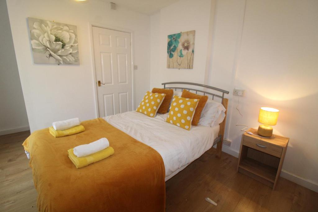 a bedroom with a bed with yellow pillows on it at Winslow Green House in Derby