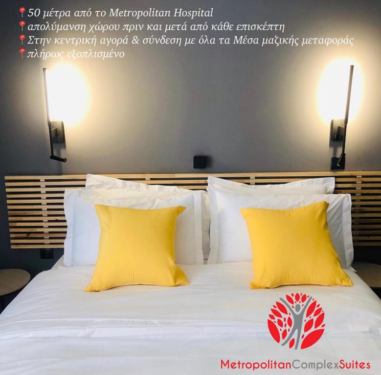 uma cama branca com duas almofadas amarelas em Metropolitan Complex Suite 2@faliro em Pireu